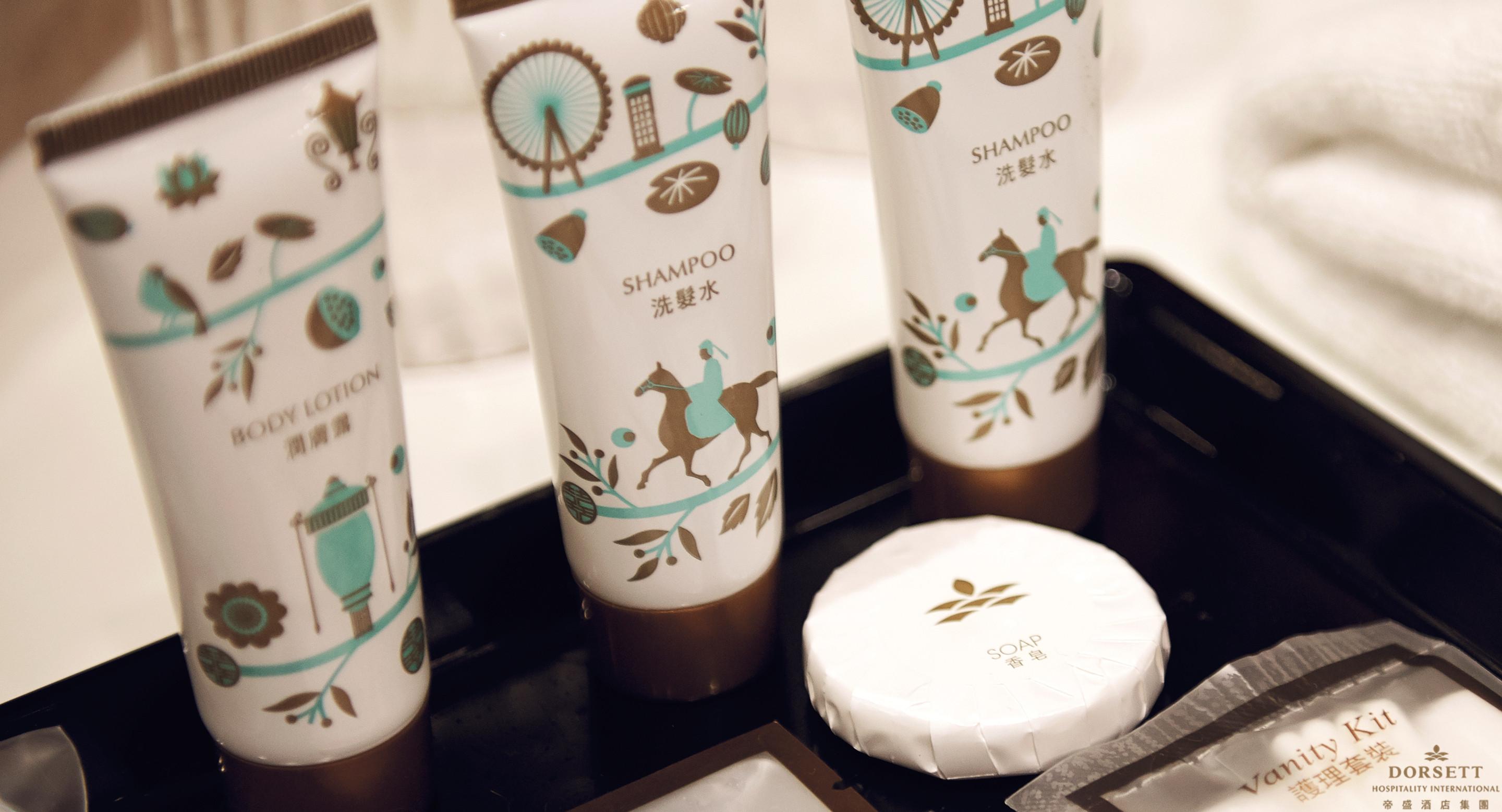 Hotel Dorsett Putrajaya Exteriér fotografie The photo shows a set of personal care products arranged on a tray. There are three tubes labeled "SHAMPOO" with a design featuring a person on horseback and other decorative elements. The tubes are predominantly white with teal and brown accents. Ad