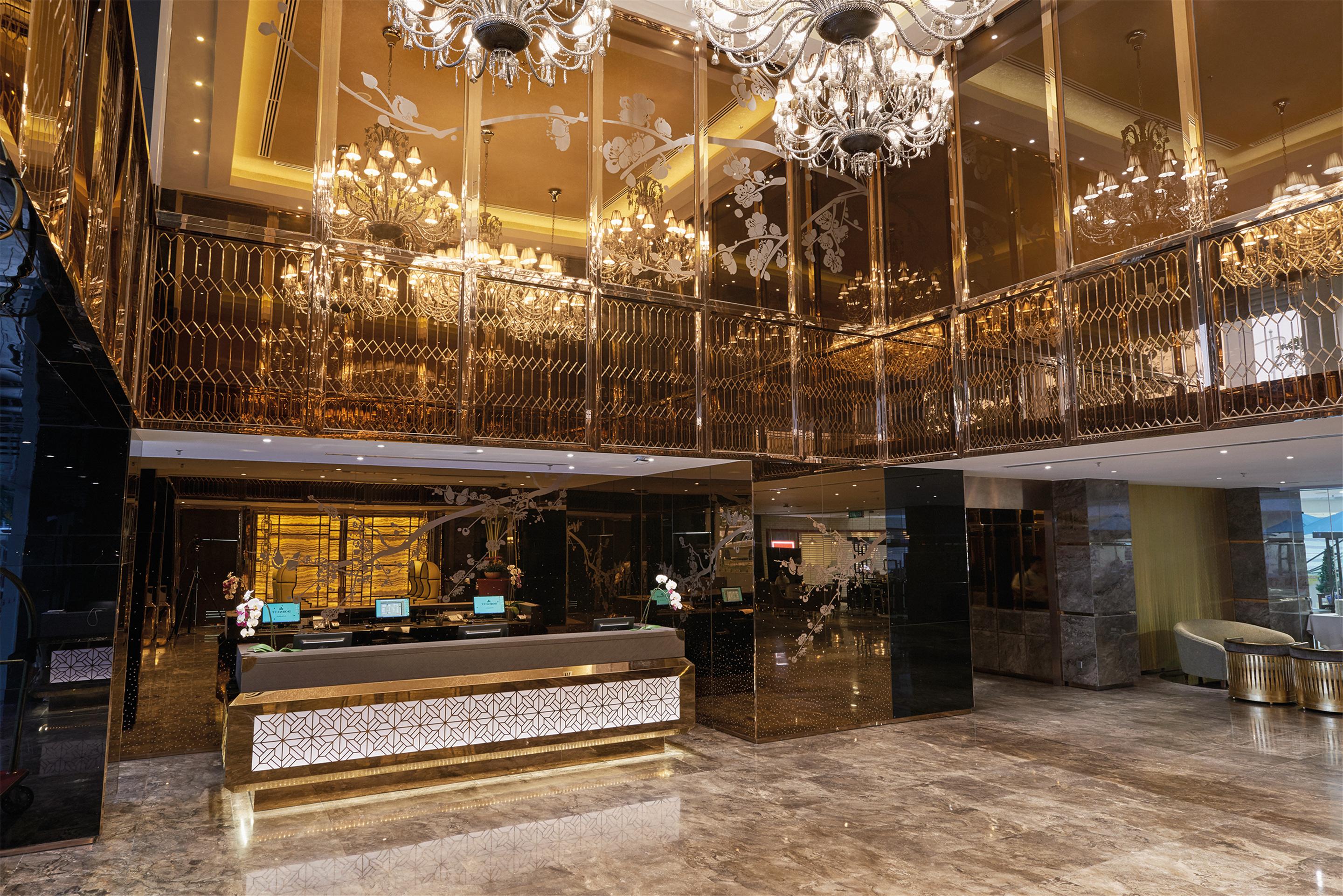 Hotel Dorsett Putrajaya Exteriér fotografie The photo shows a luxurious hotel lobby characterized by an opulent design. The space features high ceilings adorned with ornate chandeliers that provide elegant lighting. The lobby has a polished floor with a lustrous finish, and the walls are embel