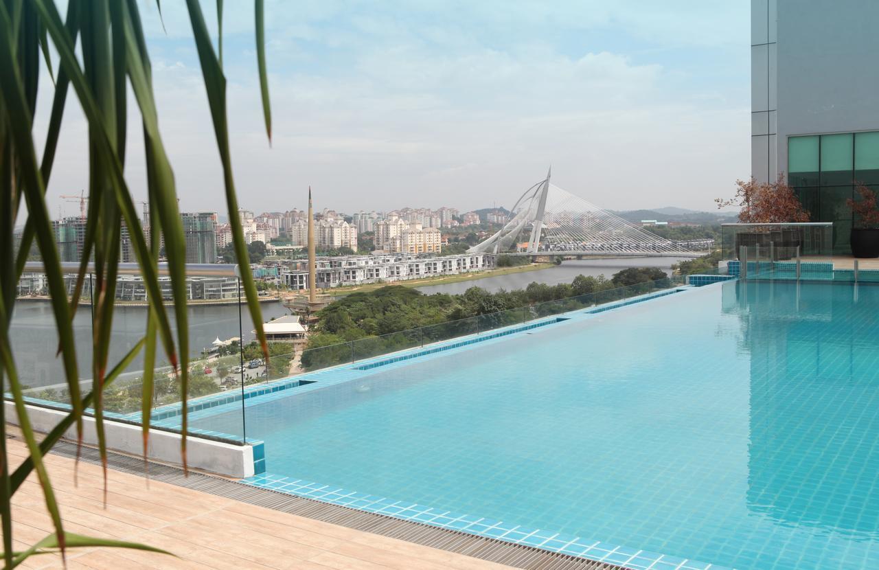 Hotel Dorsett Putrajaya Exteriér fotografie The photo shows a beautiful pool area with a stunning view. In the foreground, there is an infinity pool that creates a seamless edge with the landscape beyond. The water in the pool reflects the sky, and the overall setting appears modern and serene