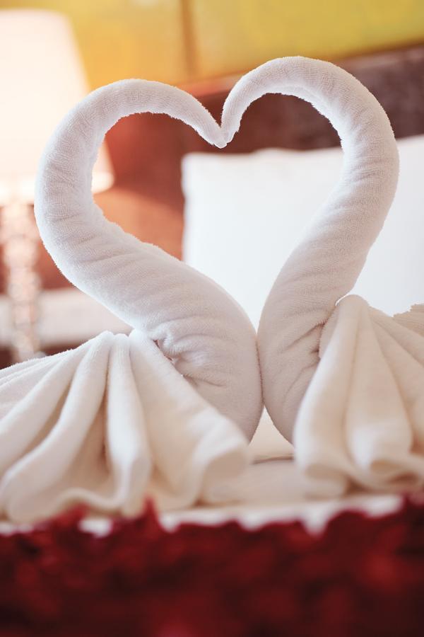 Hotel Dorsett Putrajaya Exteriér fotografie The photo shows two towel swans artfully arranged to resemble a pair of elegant swans. Their necks curve gracefully towards each other, and the towels are draped in a way that mimics the wings and body of the swans. The overall effect is decorative a