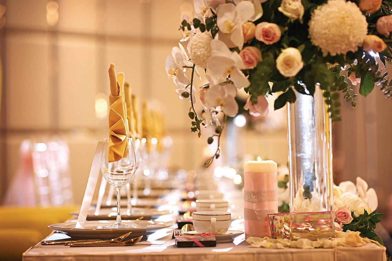 Hotel Dorsett Putrajaya Exteriér fotografie The photo shows a beautifully arranged dining table, likely set for a special event or celebration. There are elegant place settings with glassware, neatly folded napkins, and decorative elements. A striking floral centerpiece featuring white orchids